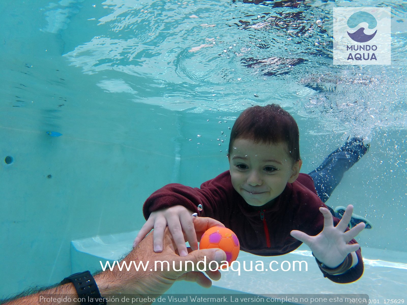Bebé feliz nadando bajo el agua en sesión clase MundoAqua